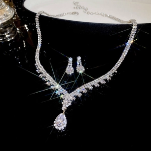 Macro shot of silver teardrop necklace and earrings set with brilliant sparkling crystals