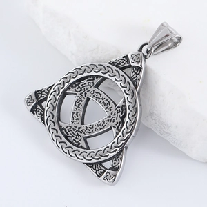 Détail macro du pendentif triangle viking avec nœud celtique argenté sur pierre