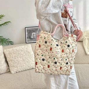 Detailed view of quilted cotton tote bag with holiday pattern and woven handles
