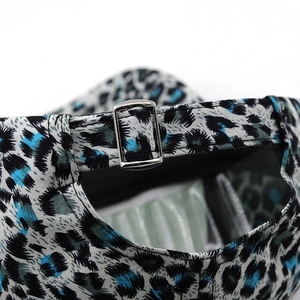 Detail of adjustable silver metal buckle and blue leopard print fabric on baseball cap