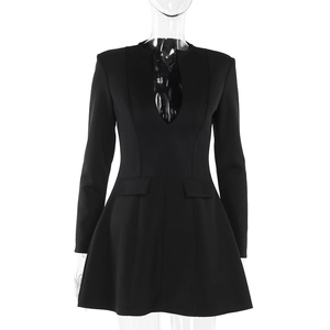 Detail of black long-sleeve dress featuring a deep V-neckline and decorative waist pockets