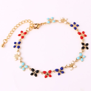 Macro detail of gold-plated alloy bracelet with colorful enamel flower pendants and lobster clasp