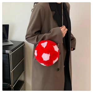 Detail of red plush heart pattern crossbody bag with a delicate gold chain strap