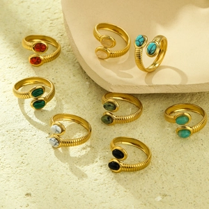 Gold stainless steel open rings with oval natural stones and textured bands on beige base