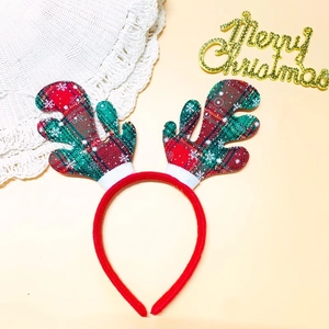 Détail du serre-tête de bois de renne de Noël avec des motifs à carreaux rouges et verts
