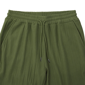 Detail of army green ribbed texture fabric with elastic drawstring waistband on casual pants