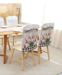 Close-up of Christmas gnome chair covers with gray fabric and festive holiday prints