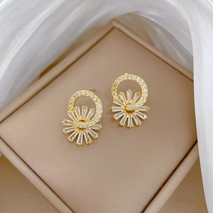 Close-up of gold flower earrings with zircon micro-inlay in a luxury gift box