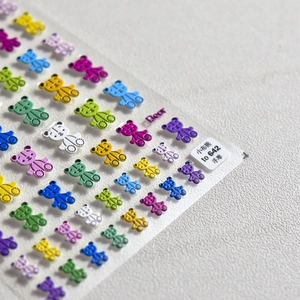 Detailed macro view of 3D embossed teddy bear nail art stickers with textured finish