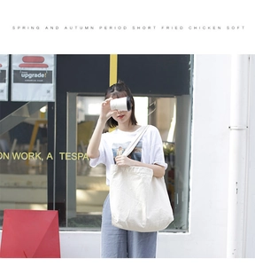 Close-up of durable white cotton canvas tote bag with reinforced shoulder straps