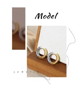 Detail of minimalist two-tone gold and silver circular hoop earrings in titanium steel