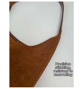 Macro detail of dark brown suede tote showing precise stitching and durable shoulder strap
