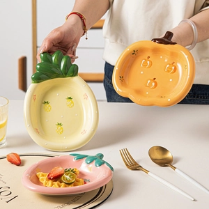 Three cute ceramic bowls in pineapple, pumpkin and strawberry shapes for salad and desserts