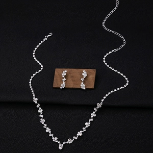 Close-up of sparkling zircon flower necklace and teardrop tassel earrings for wedding