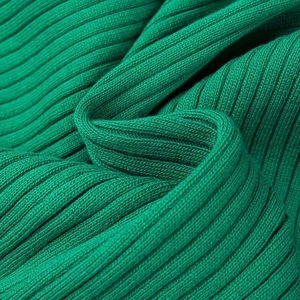 Gros plan sur la texture en tricot côtelé vert montrant la matière douce du pull