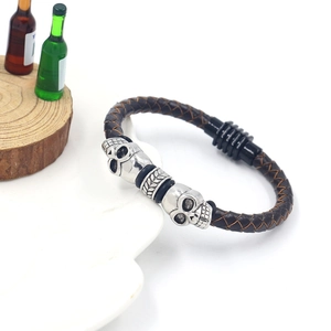 Men's punk woven leather bracelet with dual skull metal charms and a magnetic clasp