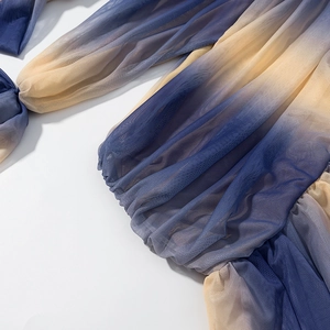 Detailed view of blue and yellow gradient mesh fabric with pleated cinched cuffs