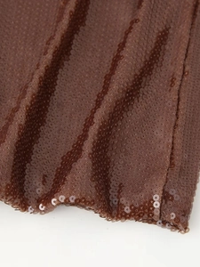 Detailed close-up of dark brown sequin fabric with high-density scale-like layering