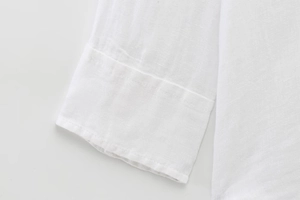 Close-up of the clean white cuffs and woven cotton texture on this long sleeve shirt