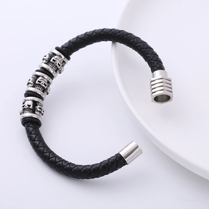 Men's braided black leather bracelet with three silver metal skulls and magnetic clasp