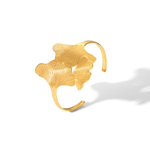 Dettaglio del bracciale rigido dorato a foglia di ginkgo con trame di venature fini