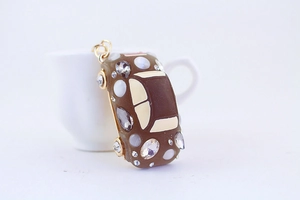 Detailed close-up of brown car keychain with sparkling rhinestones and white pearls