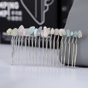Macro shot of handmade hair comb featuring natural crystal stones and silver metal teeth