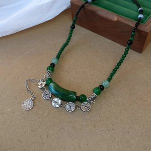 Détail du collier de perles avec tube de résine bambou vert et pièces en argent