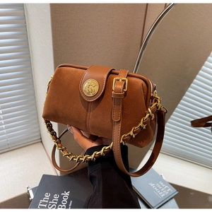 Close-up of brown suede bag featuring a vintage metal clasp and elegant chain strap