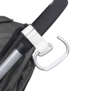 Detail of silver alloy stroller hook with white leather strap on grey handlebar