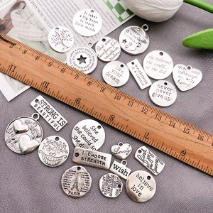 Vintage silver alloy letter charms for DIY jewelry making shown with a wooden ruler