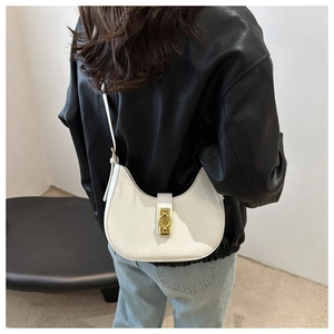 Rear view of model holding a white crescent shoulder bag with a gold metal clasp
