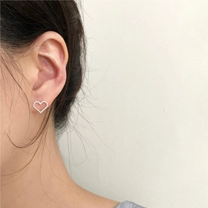 Close-up of minimalist heart stud earring with twisted rope texture on a model ear