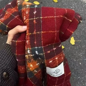 Winter red plaid cashmere-like scarf with warm autumn vibe on outdoor background