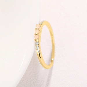 Detailansicht eines Goldrings mit drei runden Opalen und kleinen Diamantakzenten