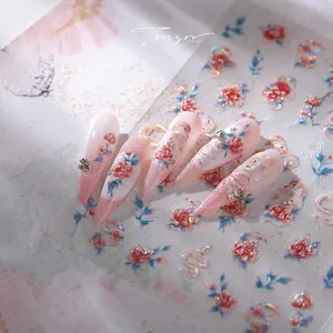 Detailed view of pink gradient stiletto nails with 3D floral and white snake embossing