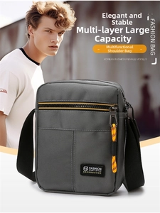 Detailed view of grey Oxford fabric crossbody bag featuring yellow zipper pullers