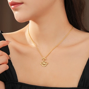 Détail d'un collier doré avec pendentif en forme de feuille d'éventail sur mannequin