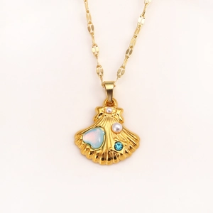Gold shell pendant necklace with pearl, heart opal and blue gemstone on white background