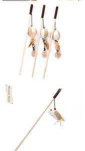 Detail of wooden cat wand with mouse pendant, feathers, and bell on a white background