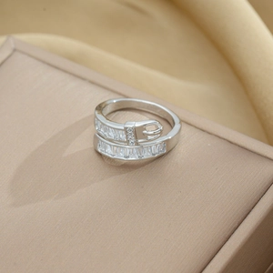 Macro shot of silver belt buckle ring with sparkling cubic zirconia on a silk background