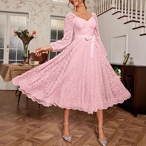 Gros plan sur la robe en dentelle rose avec col en V montrant la texture florale fine