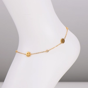 Elegantes goldenes Fußkettchen mit Smileys und Zirkonia-Anhängern auf weißem Modell
