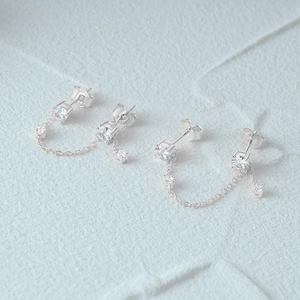 Macro detail of 925 sterling silver chain stud earrings with sparkling cubic zirconia stones
