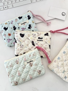 Quilted floral cosmetic pouches with cat and rabbit patterns on a white desk