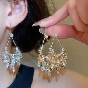 Detail showing luxurious teardrop chandelier earrings with gold plating and cubic zirconia