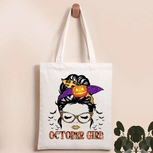 Close-up of Halloween pumpkin skull print and October Girl text on white canvas tote