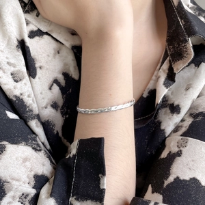 Close-up of minimalist S925 sterling silver twisted wire bangle worn on wrist