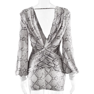 Detail of snake print dress featuring deep backless V-cut and textured ruching details
