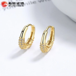 Macro detail of gold hoop earrings featuring multi-row pave white zircon inlay